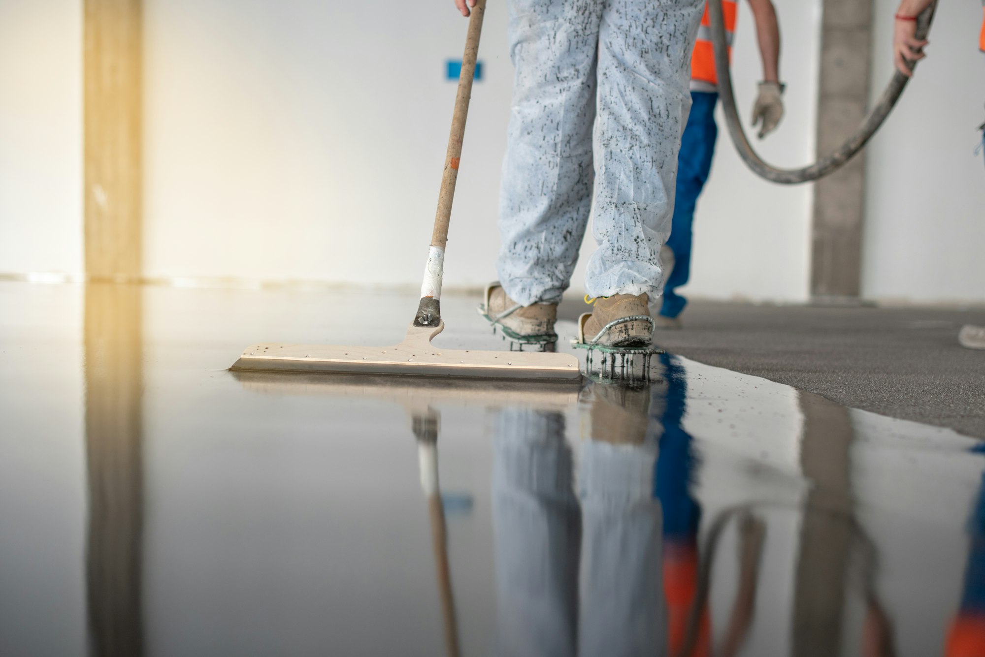 Worker working on the floor of an industrial building with special shoes to avoid damaging the floor